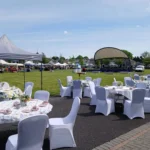 Tables and chairs set up for guests with stalls in the background