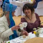 Two ladies in costume enjoy tea at the18th Century Tea Party