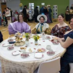 Guests in costume enjoy tea at the 18th Century Tea Party