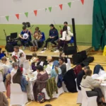 Groups of people at the 18th Century Tea Party with musicians in the background
