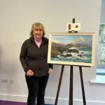 An artist with her work on display at the Art Exhibition