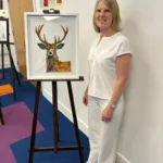 An artist with her work on display at the Art Exhibition