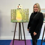 An artist with her work on display at the Art Exhibition